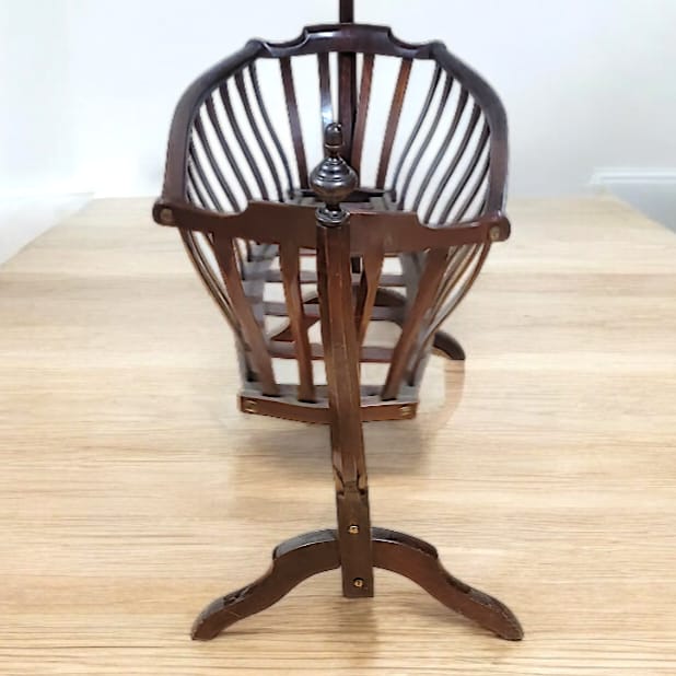 Cuna mecedora de madera oscura estilo Art Nouveau, fabricada entre 1890 y 1920, con diseño elegante y funcional.
