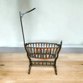 Cuna mecedora histórica estilo Art Nouveau, fabricada en Viena con madera oscura y diseño floral curvo.