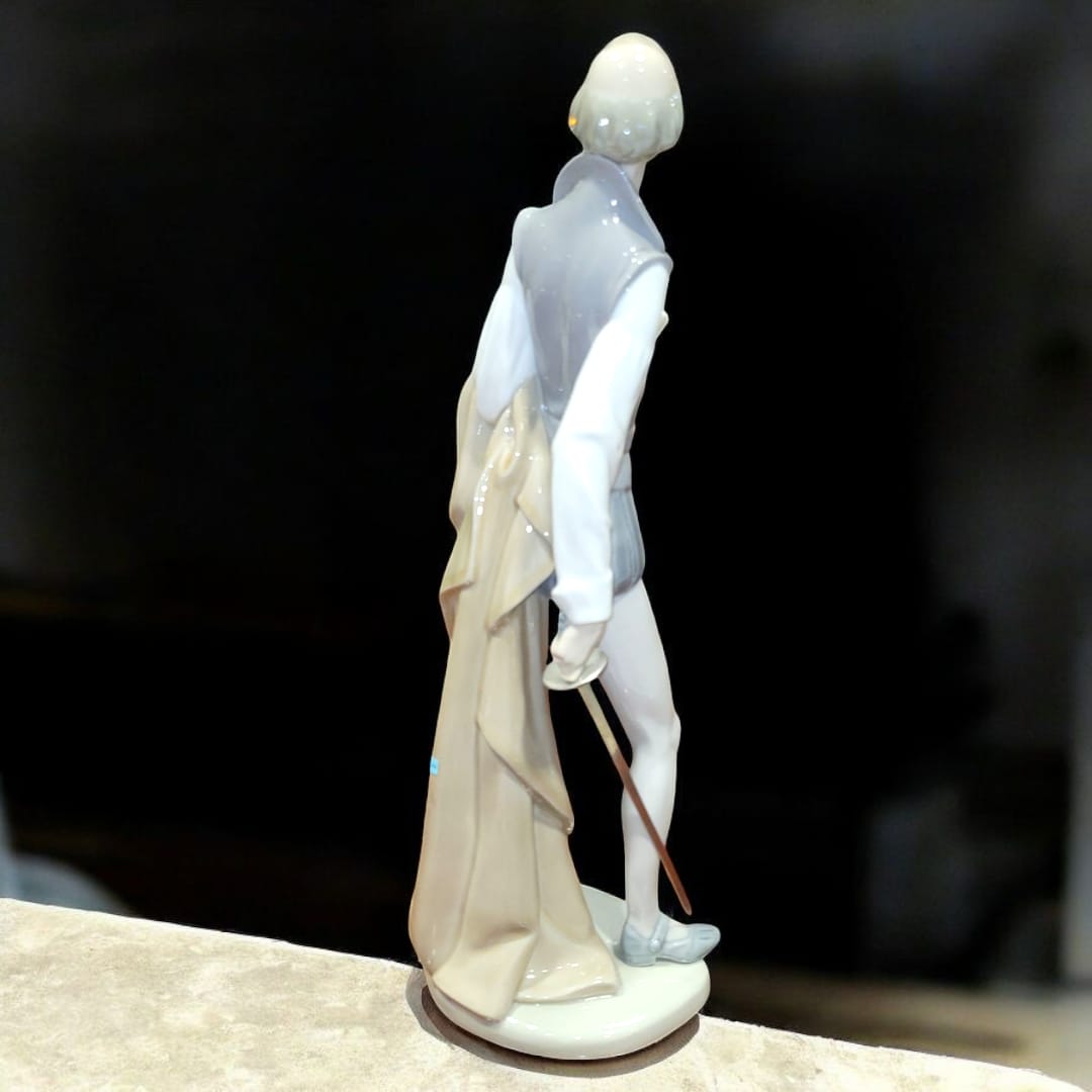 Figura decorativa de porcelana NAO LLADRÓ de Don Quijote de la Mancha vista desde atrás. Diseño detallado y acabado artesanal de alta calidad.