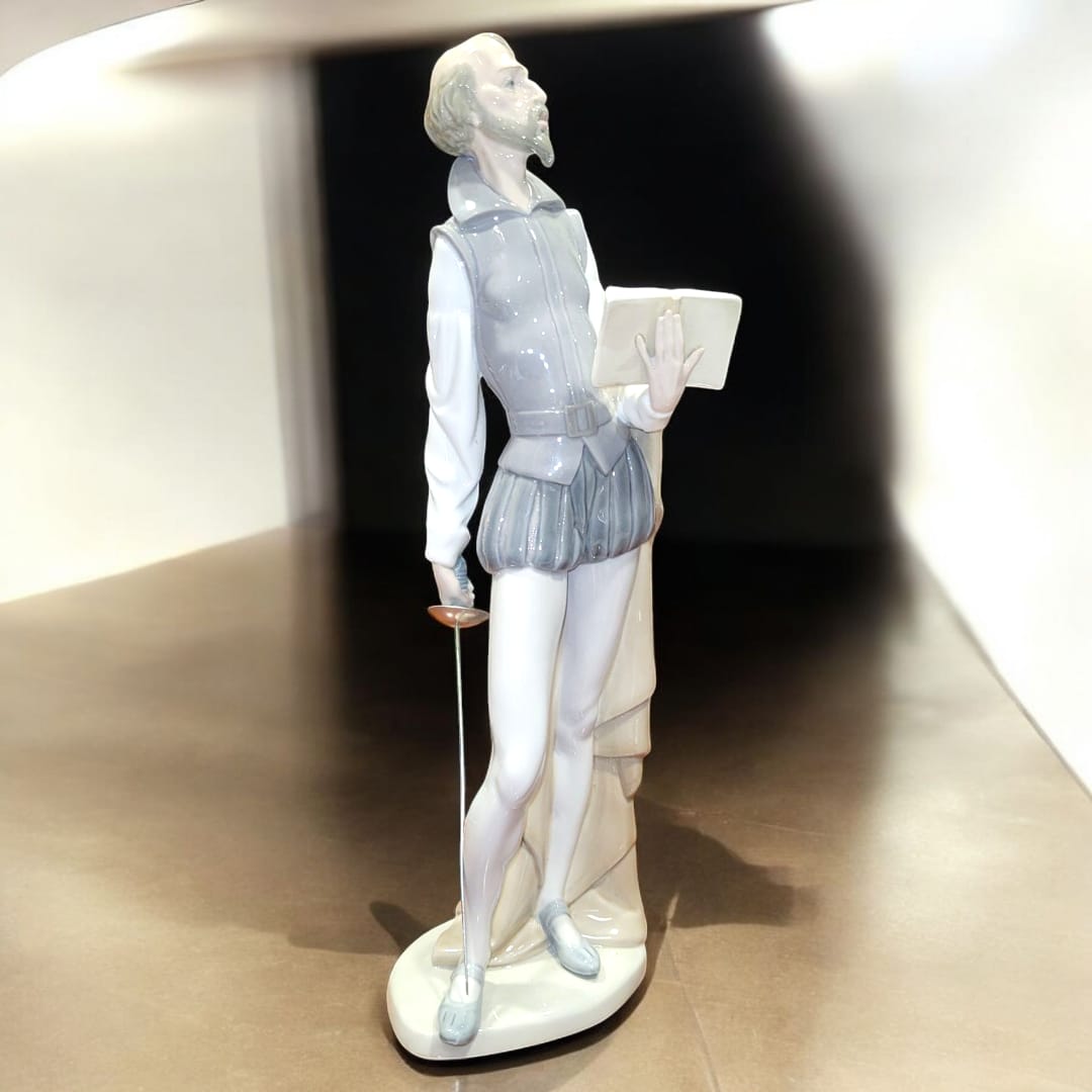 Estatuilla de porcelana NAO LLADRÓ de Don Quijote de la Mancha con espada y libro. Pieza de colección con acabados finos y elegantes.