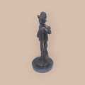 Figura antigua en bronce de niño con gorro y bastón, detalle artesanal ideal para decoración de hogar o colección de arte clásico.