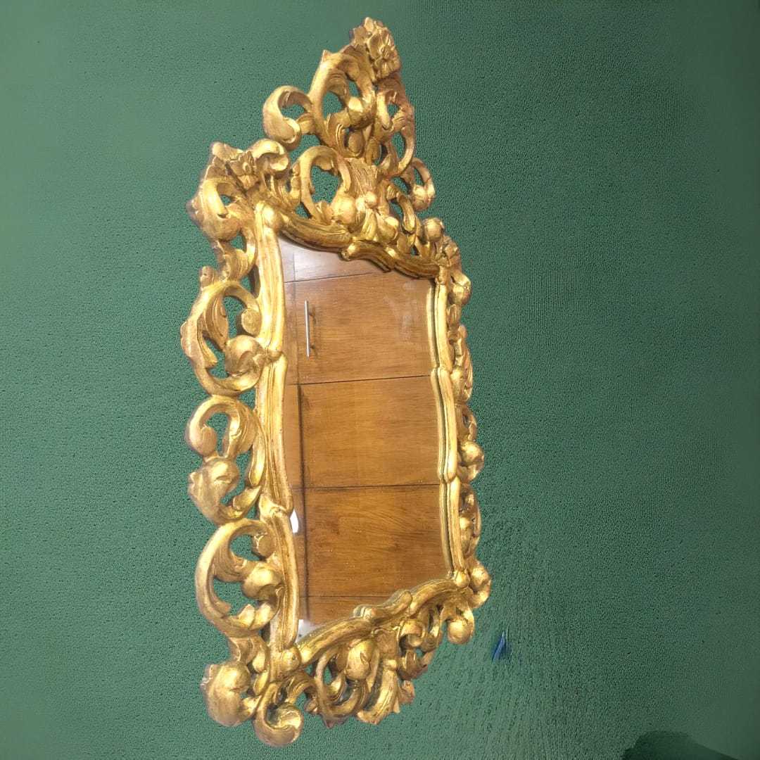 Espejo cornucopia ornamental dorado con marco tallado en estilo barroco, ideal para una decoración elegante en interiores clásicos.