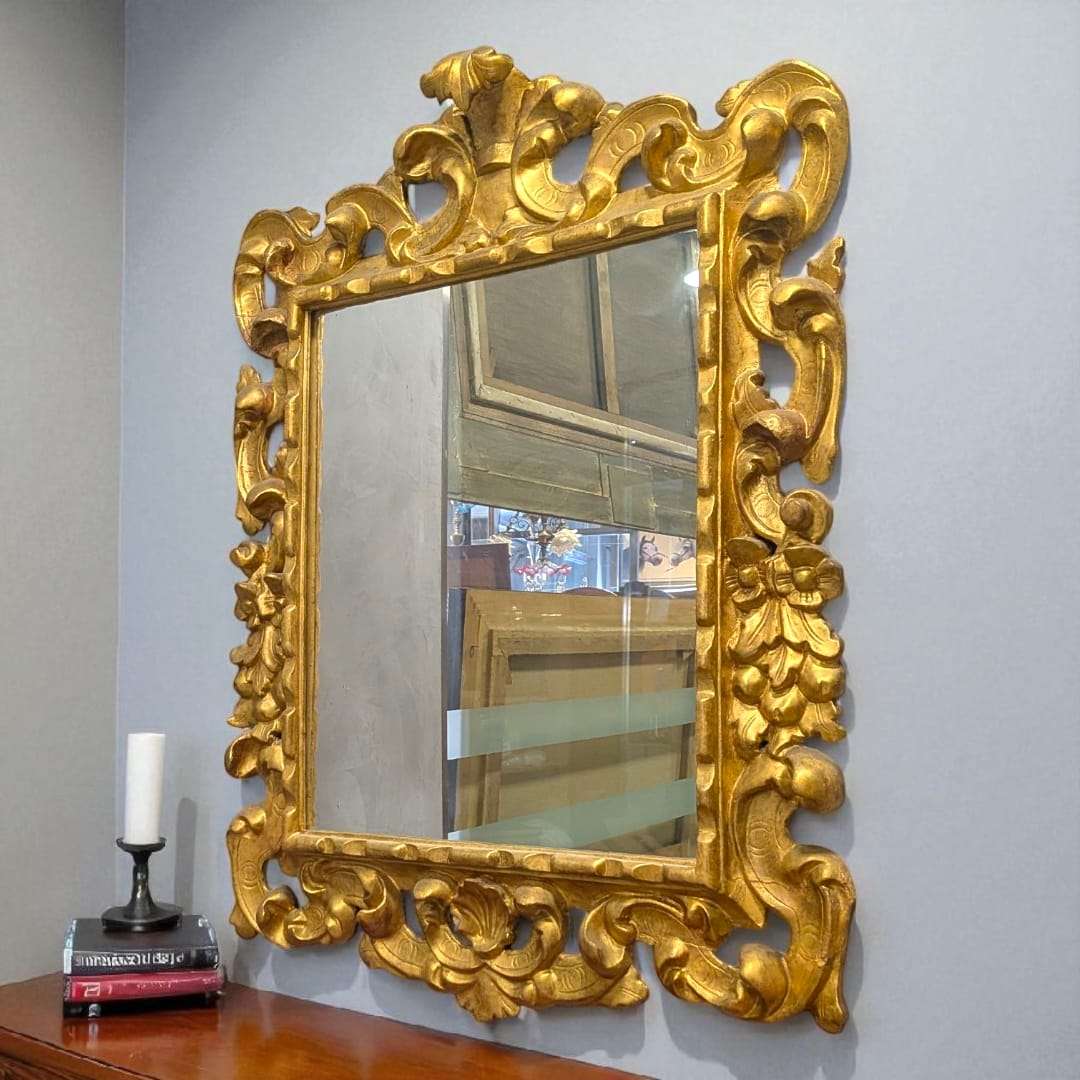 Espejo dorado isabelino del siglo XIX con talla en madera, marco ornamentado con penacho decorativo ideal para decoración clásica de interiores.