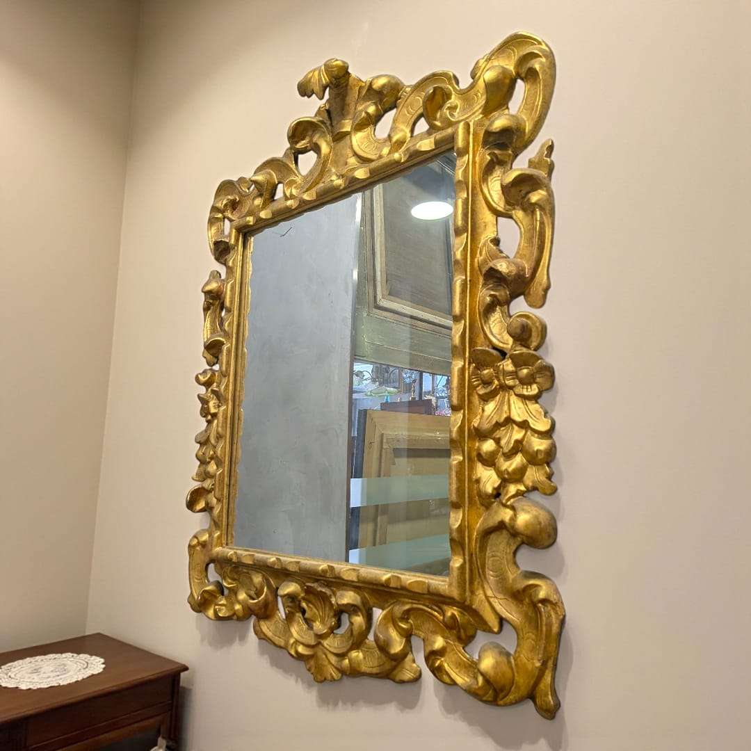 Espejo dorado isabelino del siglo XIX con talla en madera, marco ornamentado con penacho decorativo, ideal para decoración clásica de interiores.