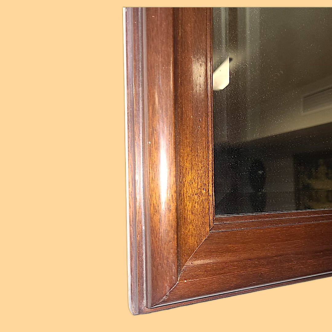 Detalle del marco de caoba del espejo, mostrando el veteado natural y la calidad de la madera