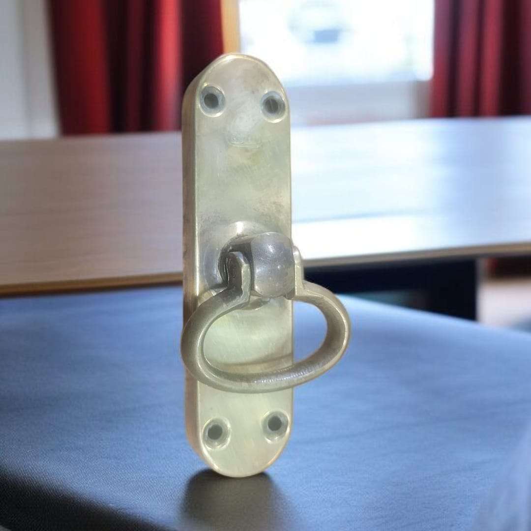 "Falleba antigua de metal dorado vista lateral sobre mesa"