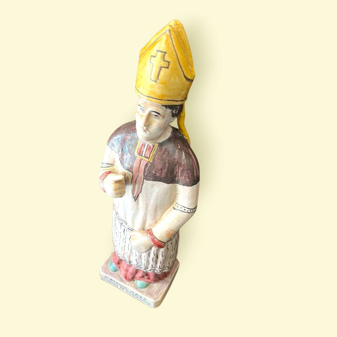Figura de terracota San Bernardo de Claraval esmaltada con mitra amarilla y túnica decorada, ideal para decoración religiosa en el hogar.