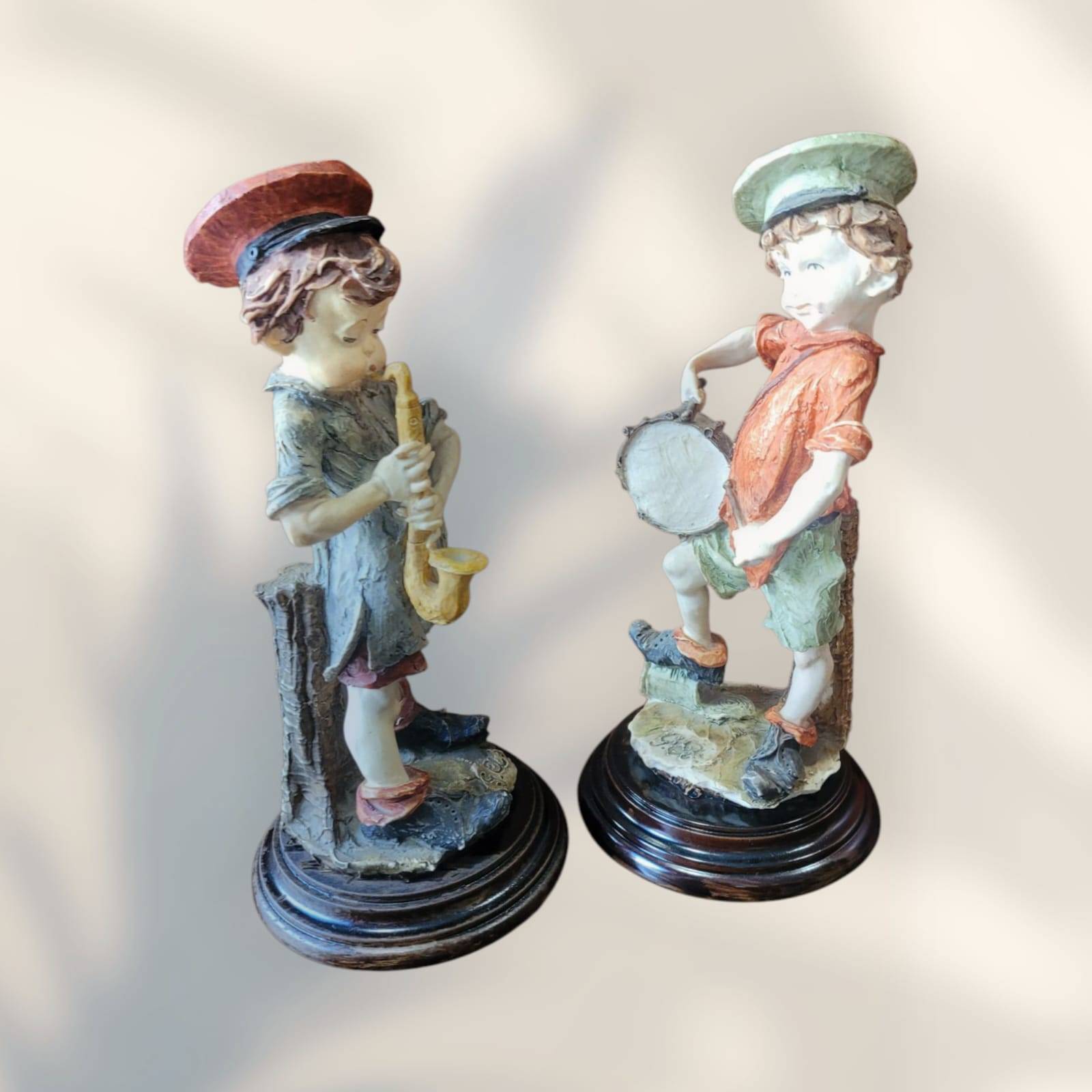 Figuras coleccionables de Giussepe Armani representando niños músicos con instrumentos, ideales para decoración artística de interiores.
