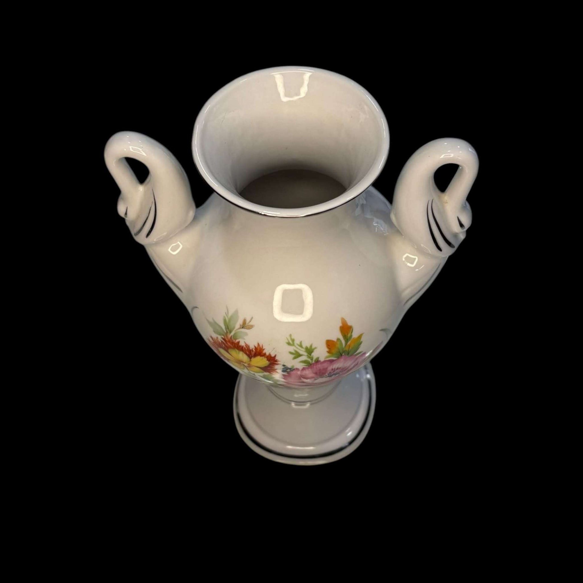 Vista cenital del florero de porcelana Bohemia con asas de cisne y borde plateado. Objeto decorativo exclusivo para amantes de la porcelana fina.