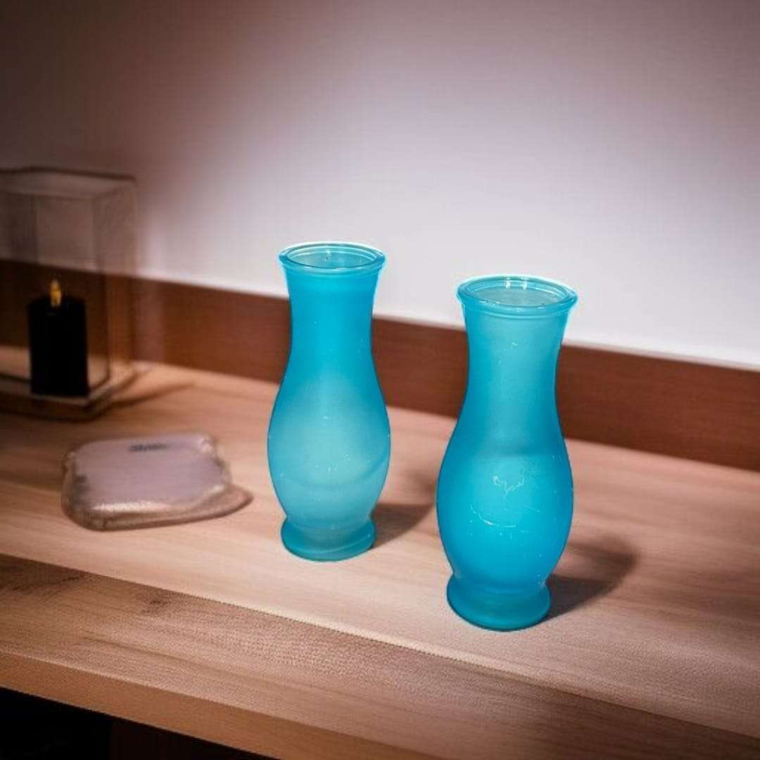 Floreros de cristal celeste con acabado semimate y diseño clásico.