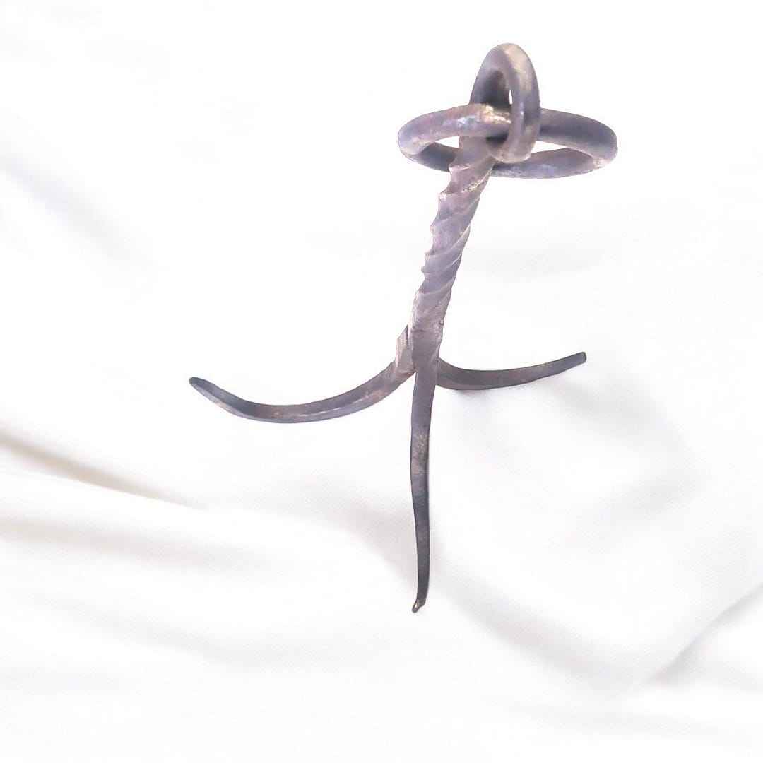 El gancho garabato de forja de tres patas es una pieza antigua forjada completamente a mano en hierro macizo, con un diseño que fusiona resistencia, técnica y arte utilitario.