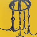Detalle de los ganchos curvados colgando, con torsiones artesanales en las cadenas.