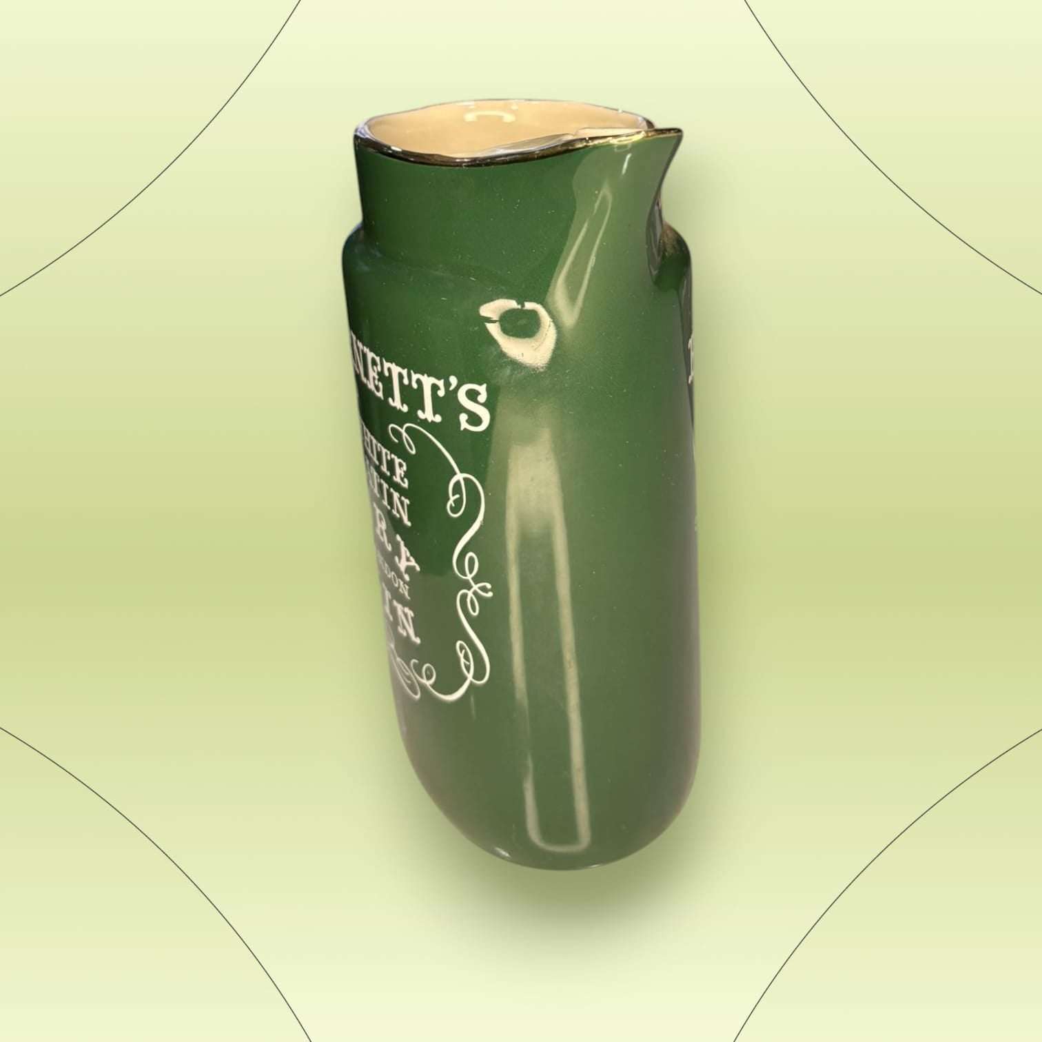 Parte trasera de la jarra de cerámica verde Burnett’s White Satin Dry Gin. Diseño antiguo perfecto para decoración de cocina o bar.