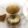 Vista superior de un jarrón de metal clásico con acabado dorado, ideal para decorar con flores y aportar un toque elegante al hogar.