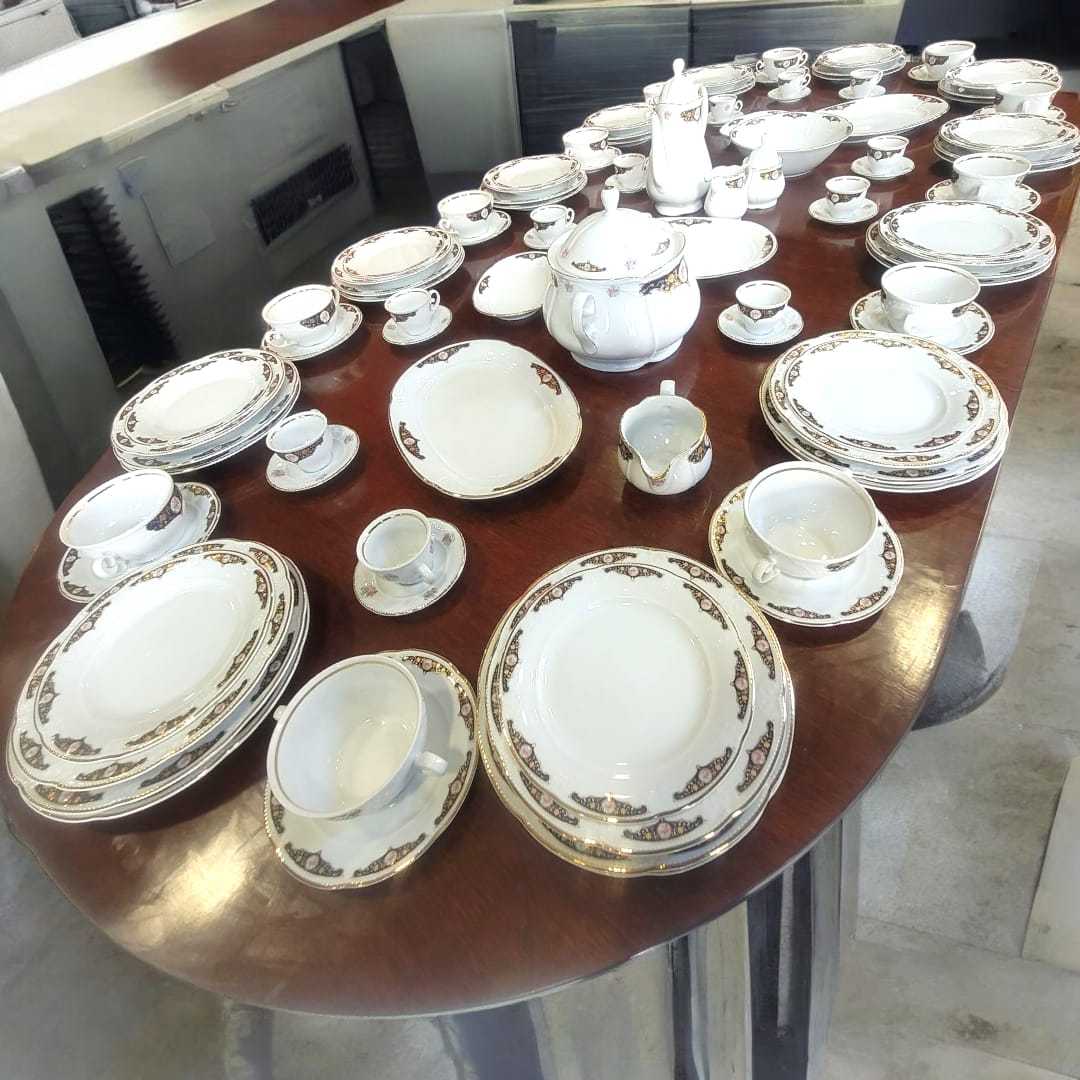 Vajilla de Bavaria, porcelana alemana – Juego completo de 107 piezas con platos, tazas y bandejas sobre mesa ovalada de madera oscura. Ideal para decoración elegante de comedor.