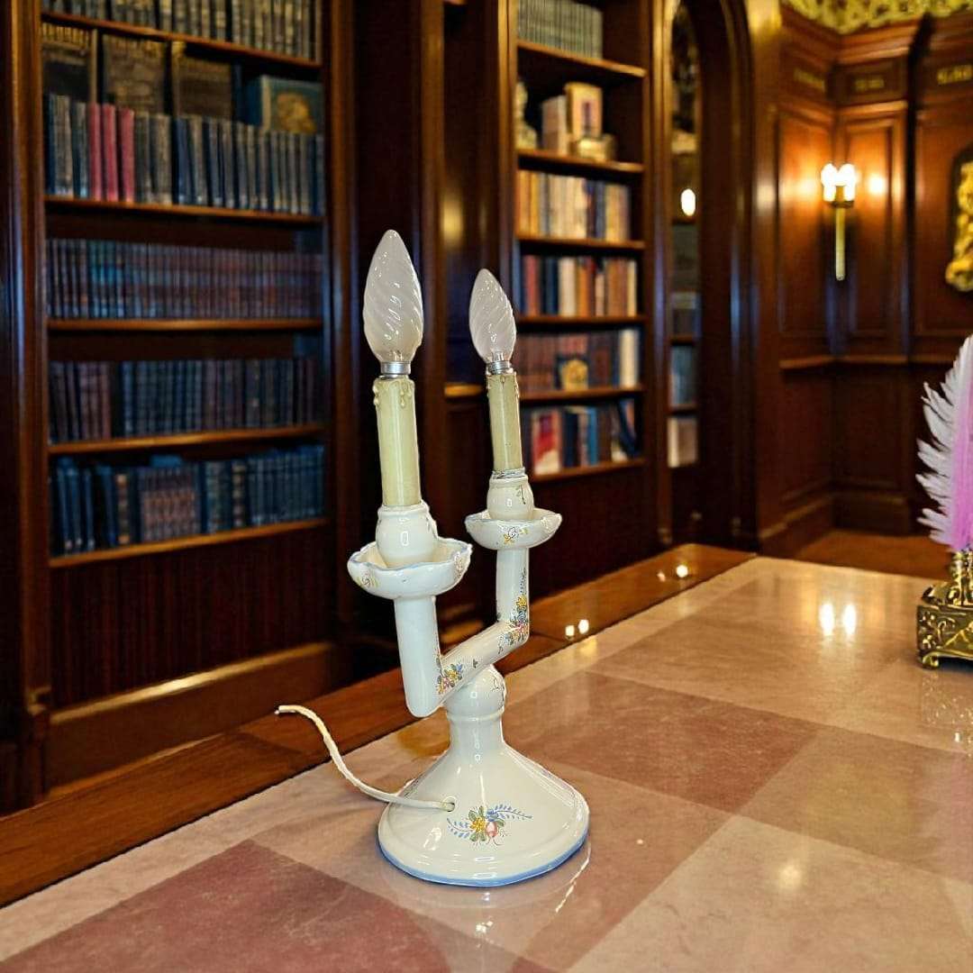 Lámpara de mesa de porcelana de Manises encendida en biblioteca clásica.