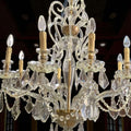 Lámpara de salón de cristal con estructura metálica dorada.