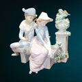 Escultura de porcelana NAO LLADRÓ 'Amor precioso' con pareja enamorada en banco, acabado en tonos suaves y detalles florales. Perfecta para decoración elegante.