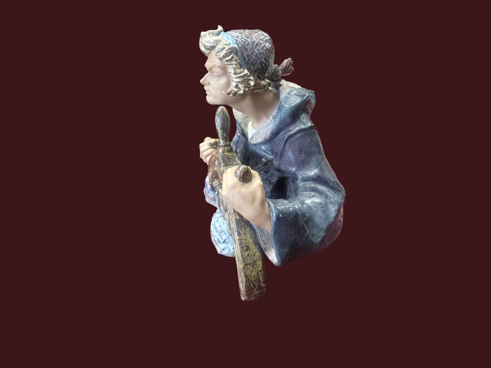 Figura decorativa Lladró "Timonel" en tonos oceánicos y terrosos sobre fondo neutro