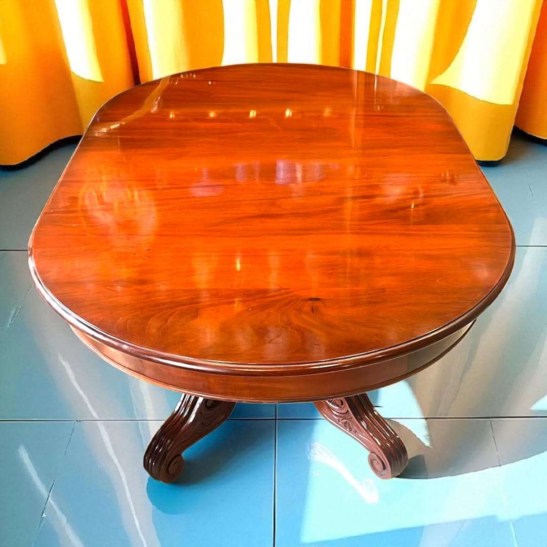 Mesa comedor de caoba antigua con forma ovalada y patas talladas, ideal para ambientes sofisticados y decoración de interiores vintage.