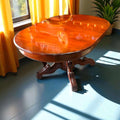 Mesa comedor de caoba antigua con patas talladas a mano, superficie ovalada brillante y acabado clásico, ideal para decoración elegante.