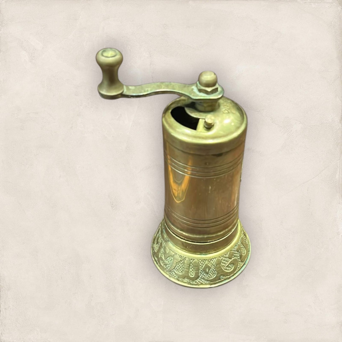 Molinillo de pimienta manual dorado de metal tallado estilo turco con diseño artesanal y manivela superior, ideal para cocina elegante.