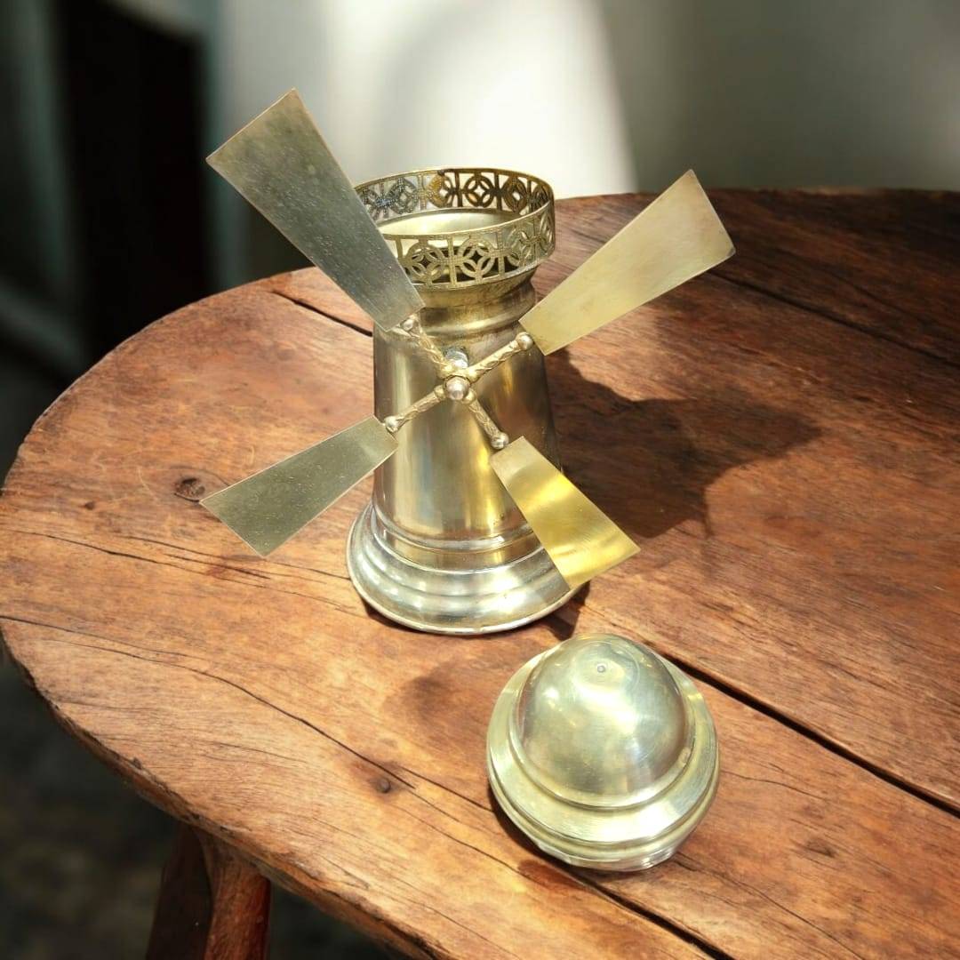 Tarro de metal dorado con forma de molino de viento, ideal para decoración de interiores en estilo vintage o rústico.