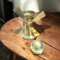Tarro decorativo de metal dorado con diseño de molino y tapa desmontable, perfecto para almacenar objetos pequeños con estilo.