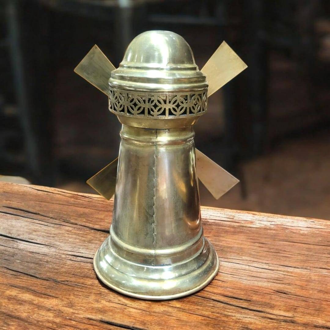 Tarro de metal dorado con detalles calados y aspas de molino, pieza decorativa para hogar o jardín con acabado brillante.