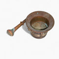 Mortero antiguo almirez en bronce dorado del siglo XVII con escudos decorativos y maja original. Ideal para decoración vintage en hogar o jardín.