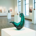 Pieza de Cristal Murano – Arte único para tu decoración en verde esmeralda con forma abstracta, expuesta en galería de arte moderna. Ideal para decoración de interiores.