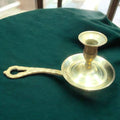 Palmatoria antigua de metal dorado con mango calado decorativo. Perfecta para ambientar espacios con un toque vintage y sofisticado.