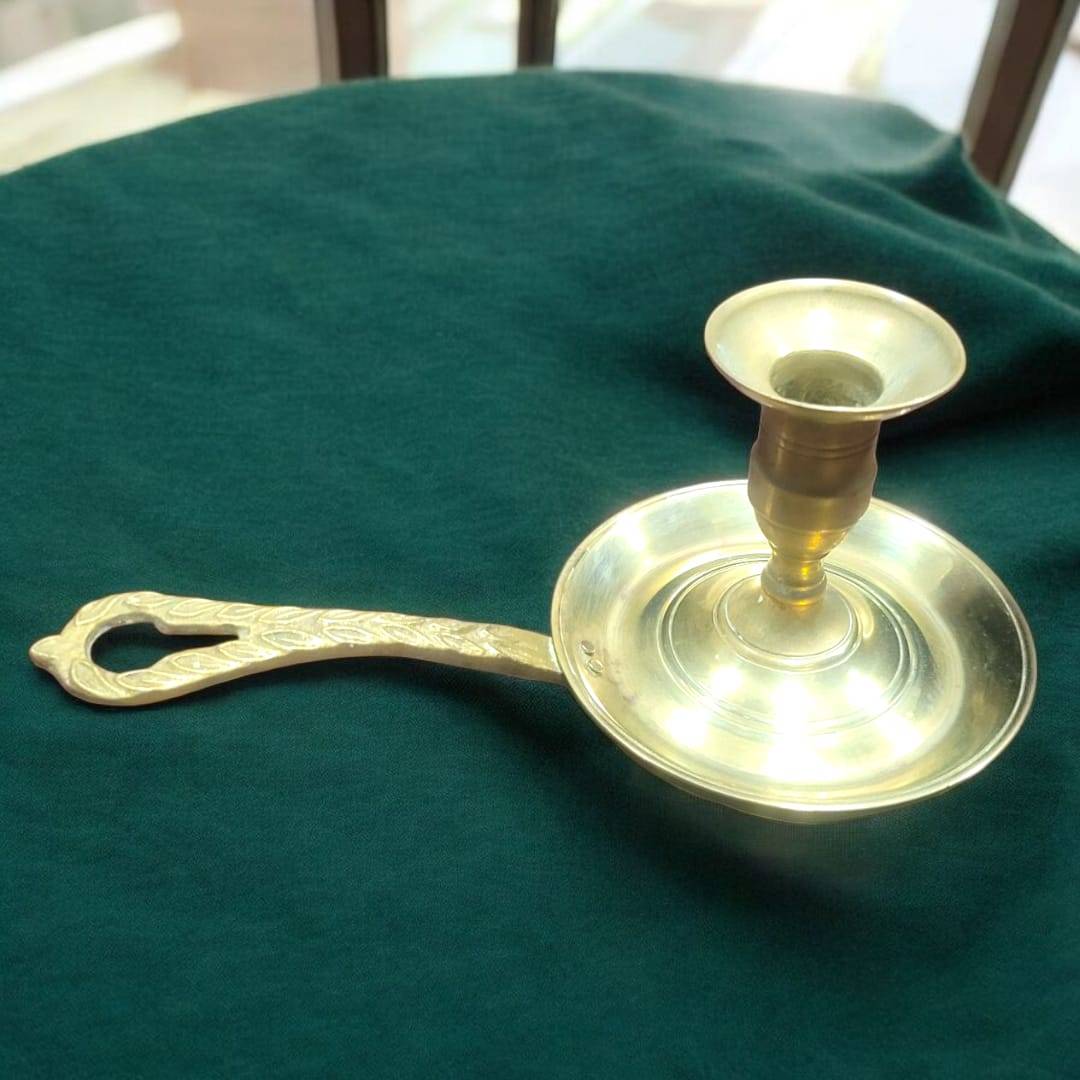 Palmatoria antigua de metal dorado con mango calado decorativo. Perfecta para ambientar espacios con un toque vintage y sofisticado.