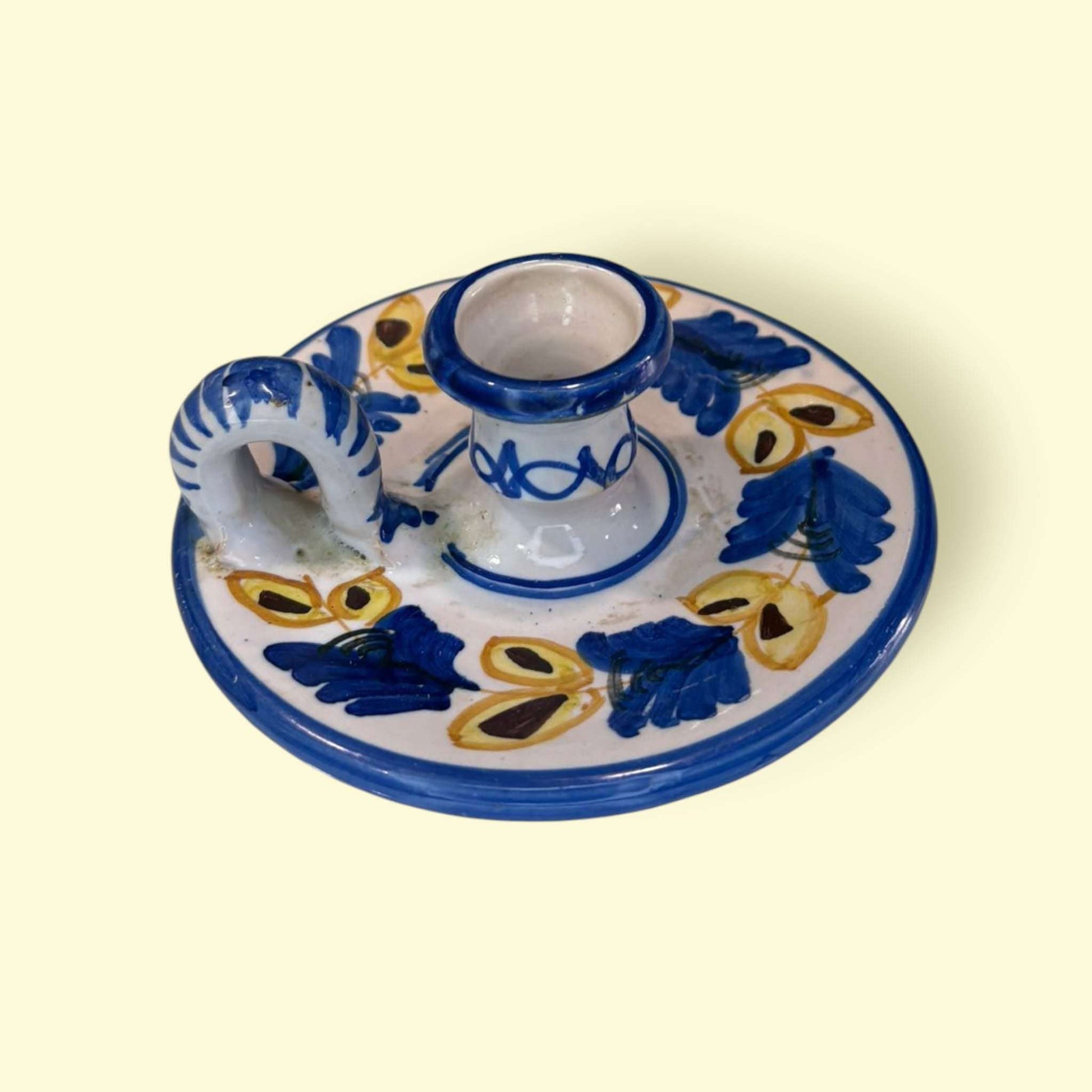 La Palmatoria de cerámica conserva a la perfección su función original, pudiendo usarse como portavelas o como pieza puramente decorativa en ambientes rústicos, vintage o mediterráneos.