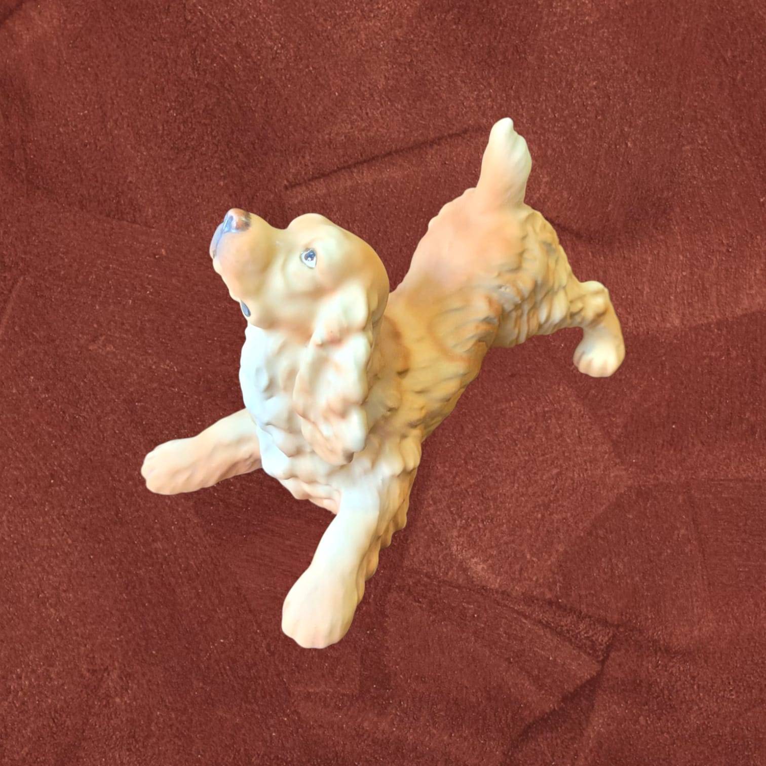 Figura Cocker Spaniel biscuit firmada por C. Martinus en pose juguetona, escultura sin esmalte ideal para decoración y coleccionistas de perros.