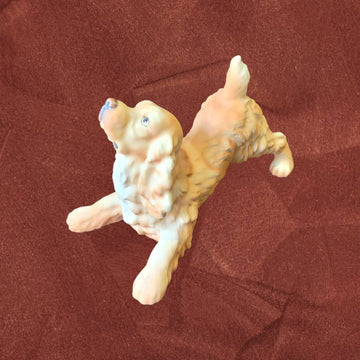 Figura Cocker Spaniel biscuit firmada por C. Martinus en pose juguetona, escultura sin esmalte ideal para decoración y coleccionistas de perros.