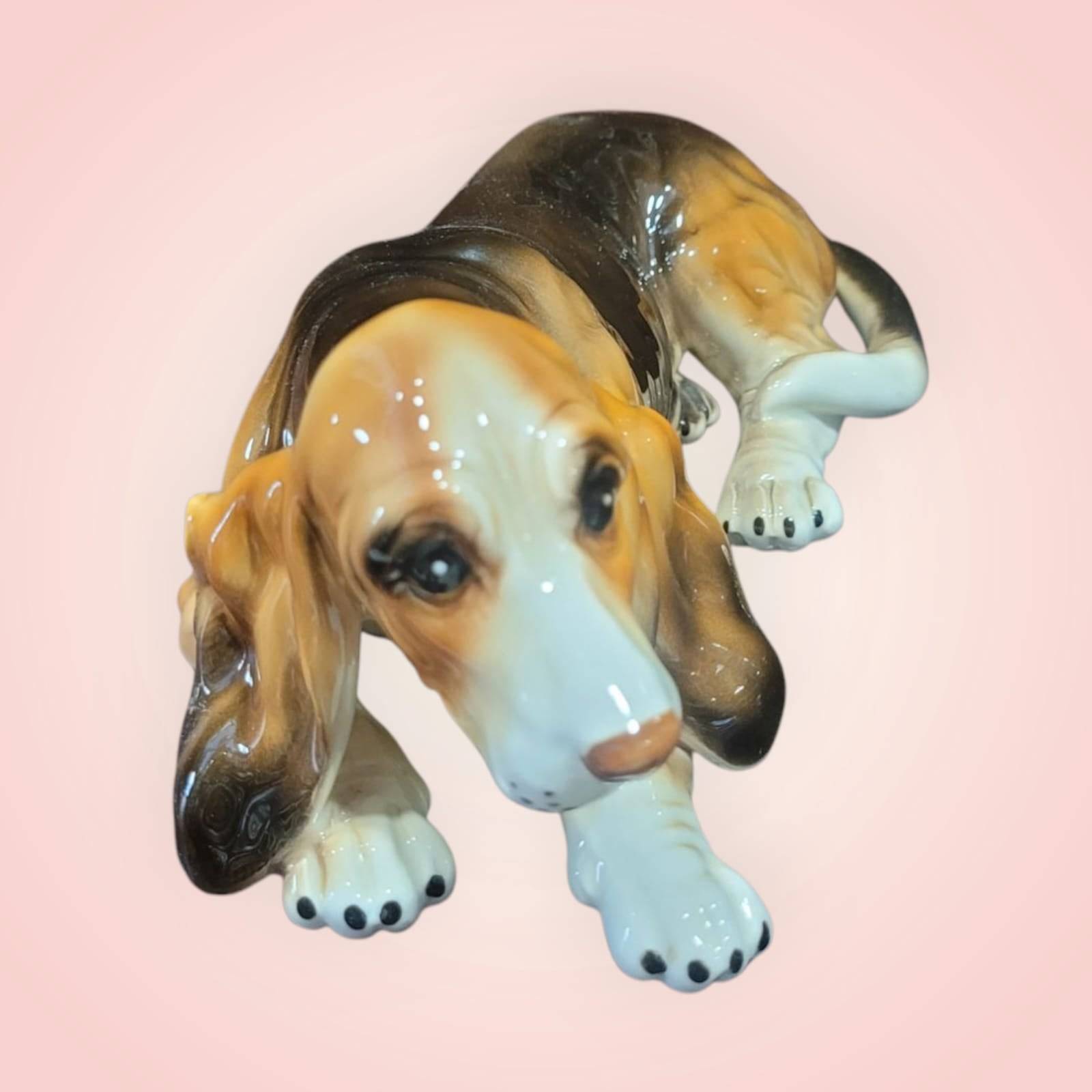 Figura decorativa de perro de porcelana Basset Hound esmaltado, con acabado brillante y detalles realistas. Ideal para decoración del hogar.