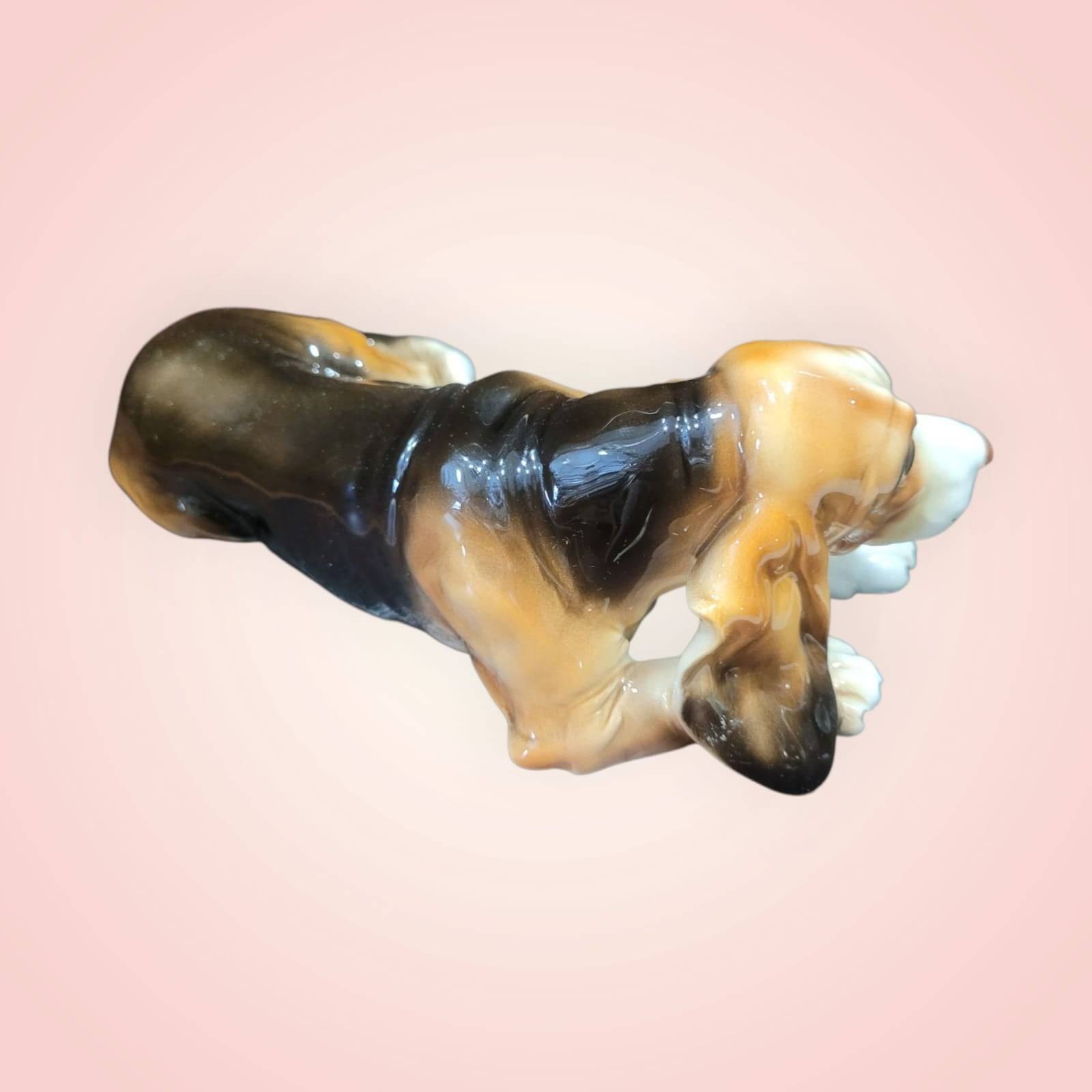 Vista superior del perro de porcelana Basset Hound decorativo, con esmaltado en tonos marrón y negro. Perfecto para coleccionistas de figuras.