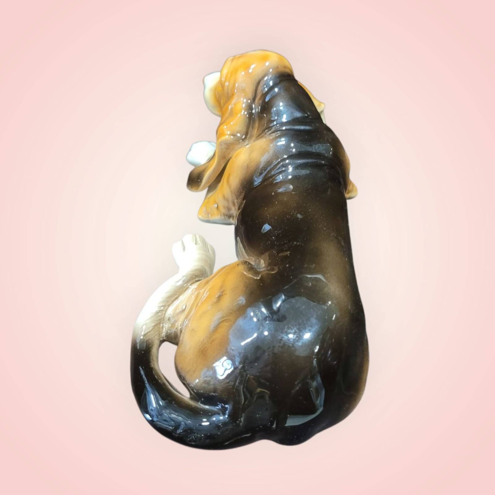 Parte trasera del perro de porcelana Basset Hound esmaltado, mostrando su acabado brillante y forma realista. Pieza de decoración elegante.