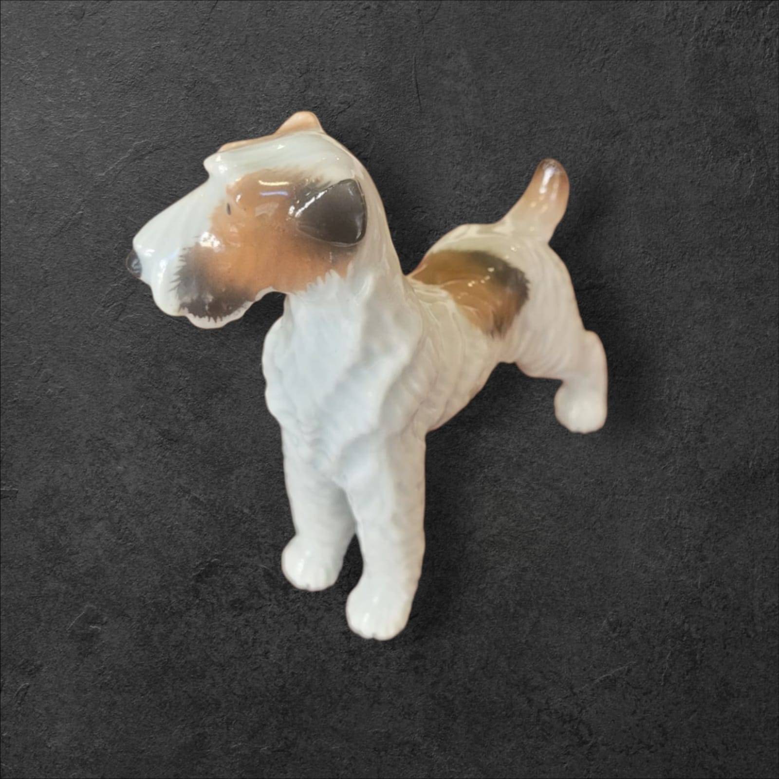 Figura de perro Fox Terrier en porcelana alemana vintage, vista lateral mostrando detalles realistas, ideal para decoración de hogar.