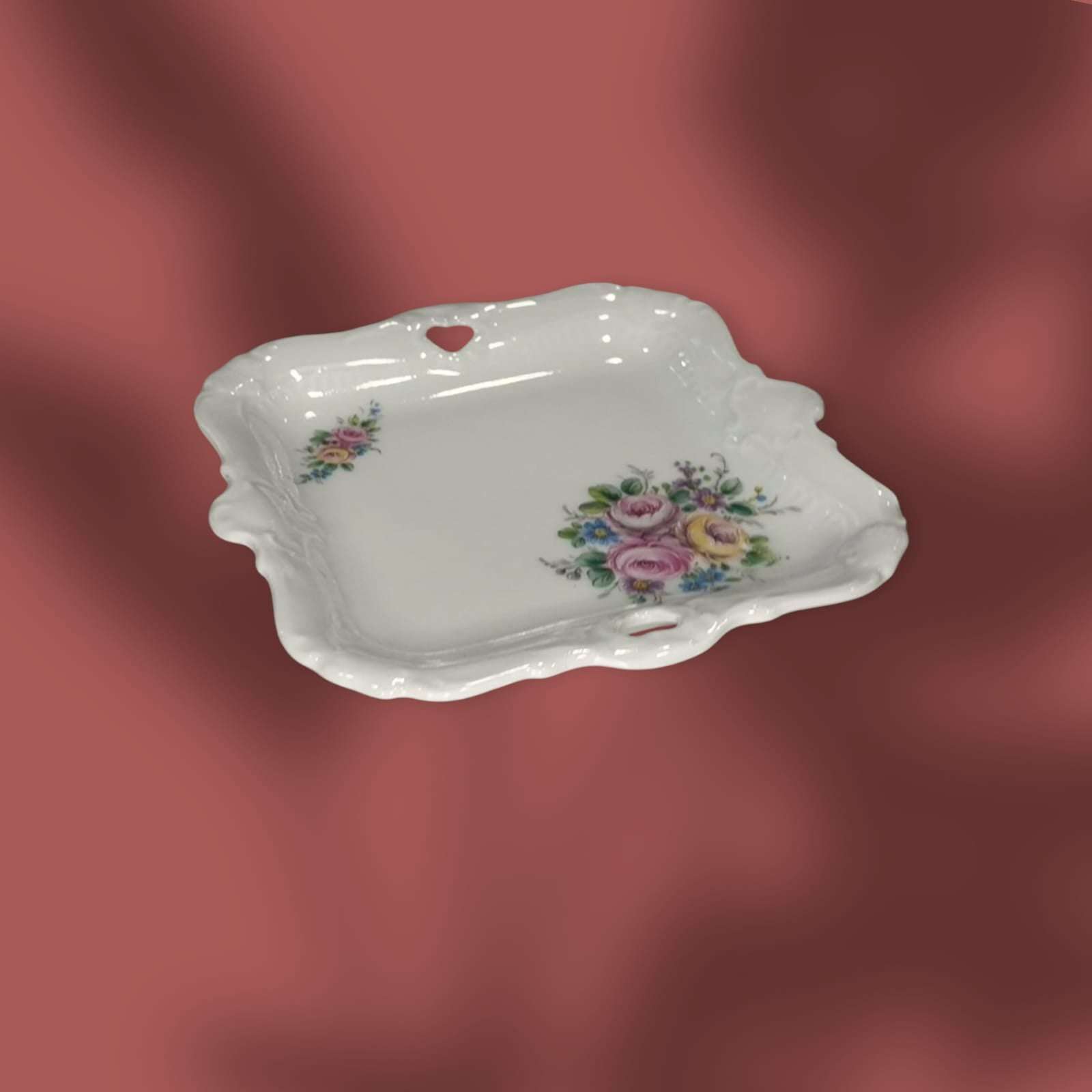 Bandejita cuadrada con flores en tonos pastel y borde ondulado.