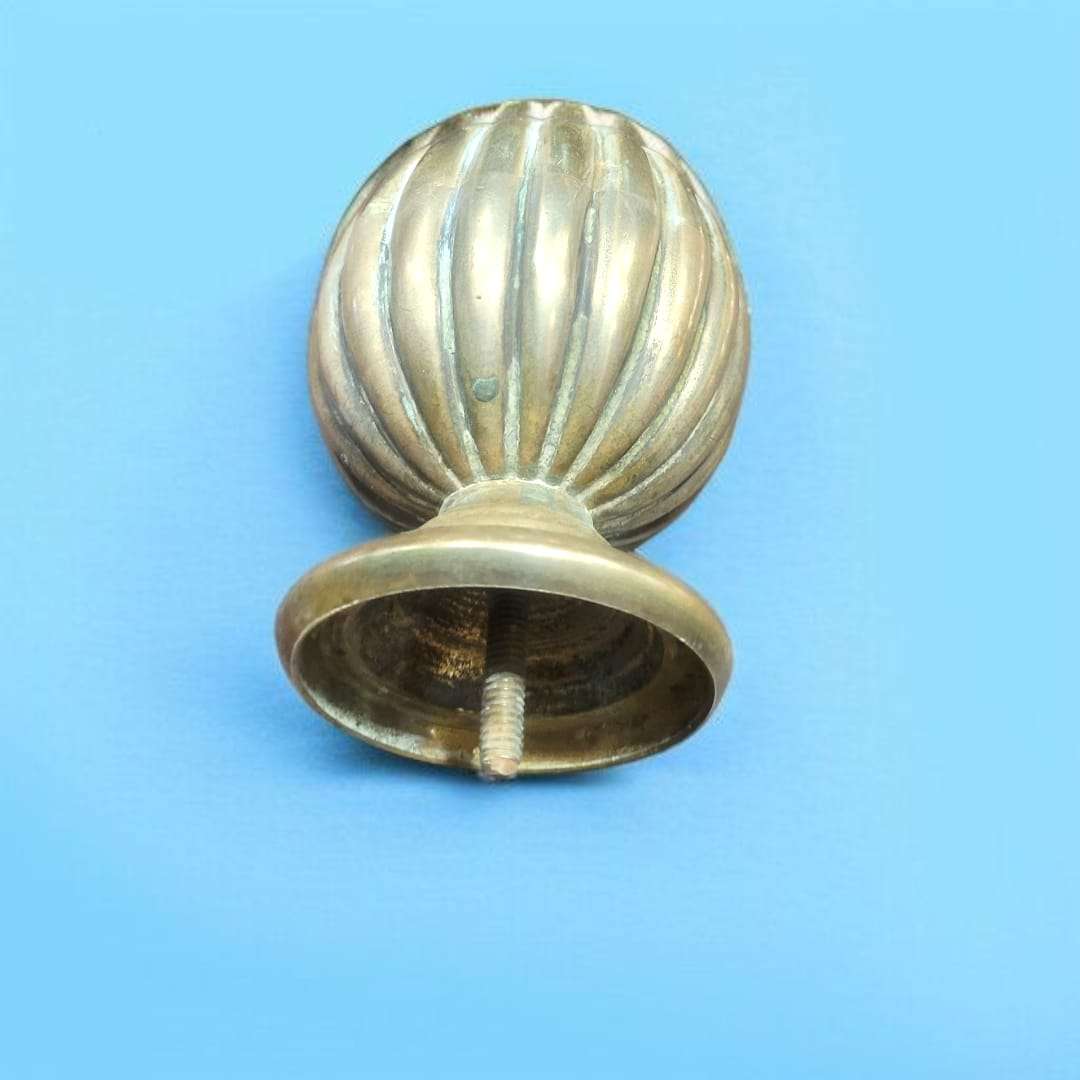 Pomo decorativo de bronce antiguo tumbado en superficie oscura