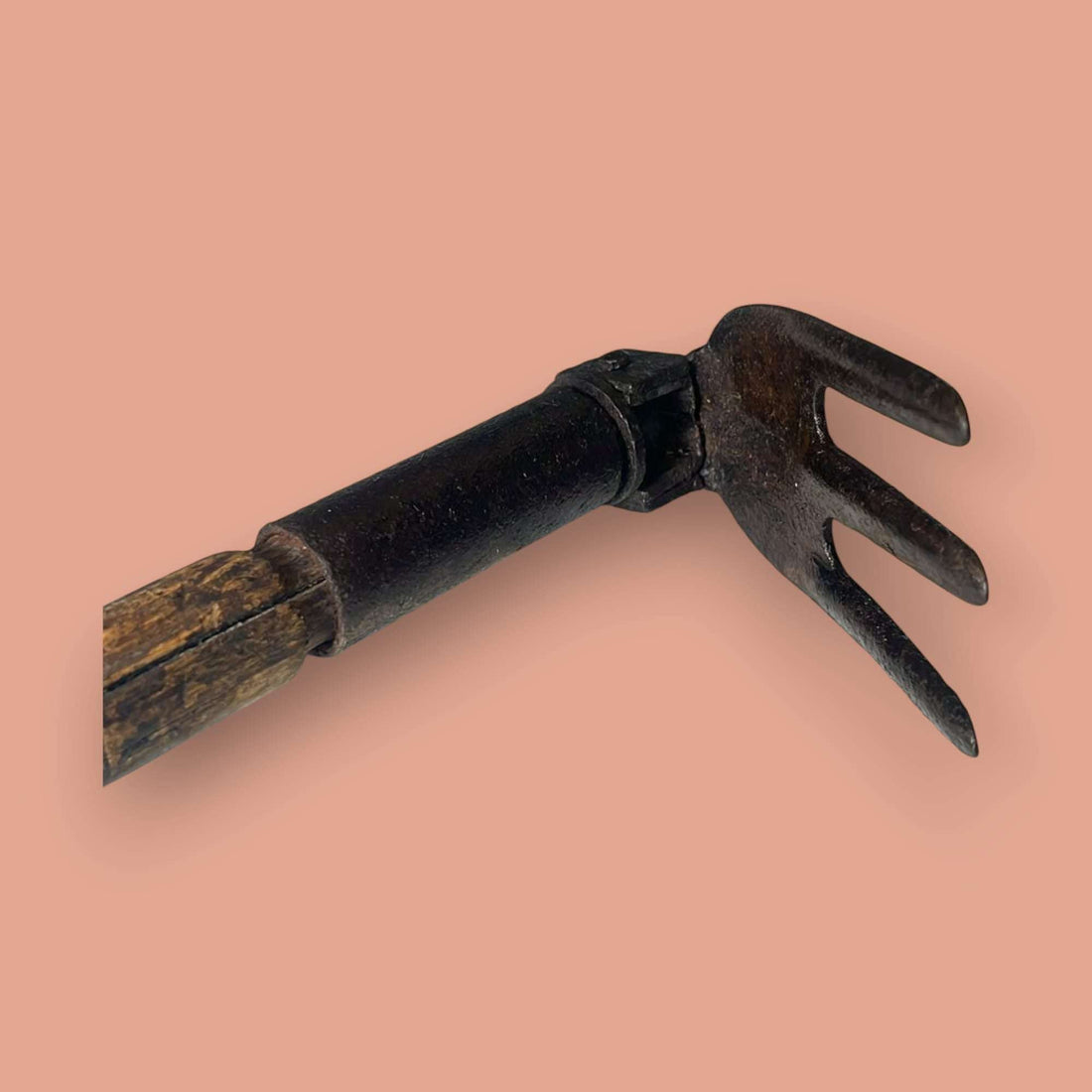 Rastrillo antiguo de hierro forjado con mango de madera.