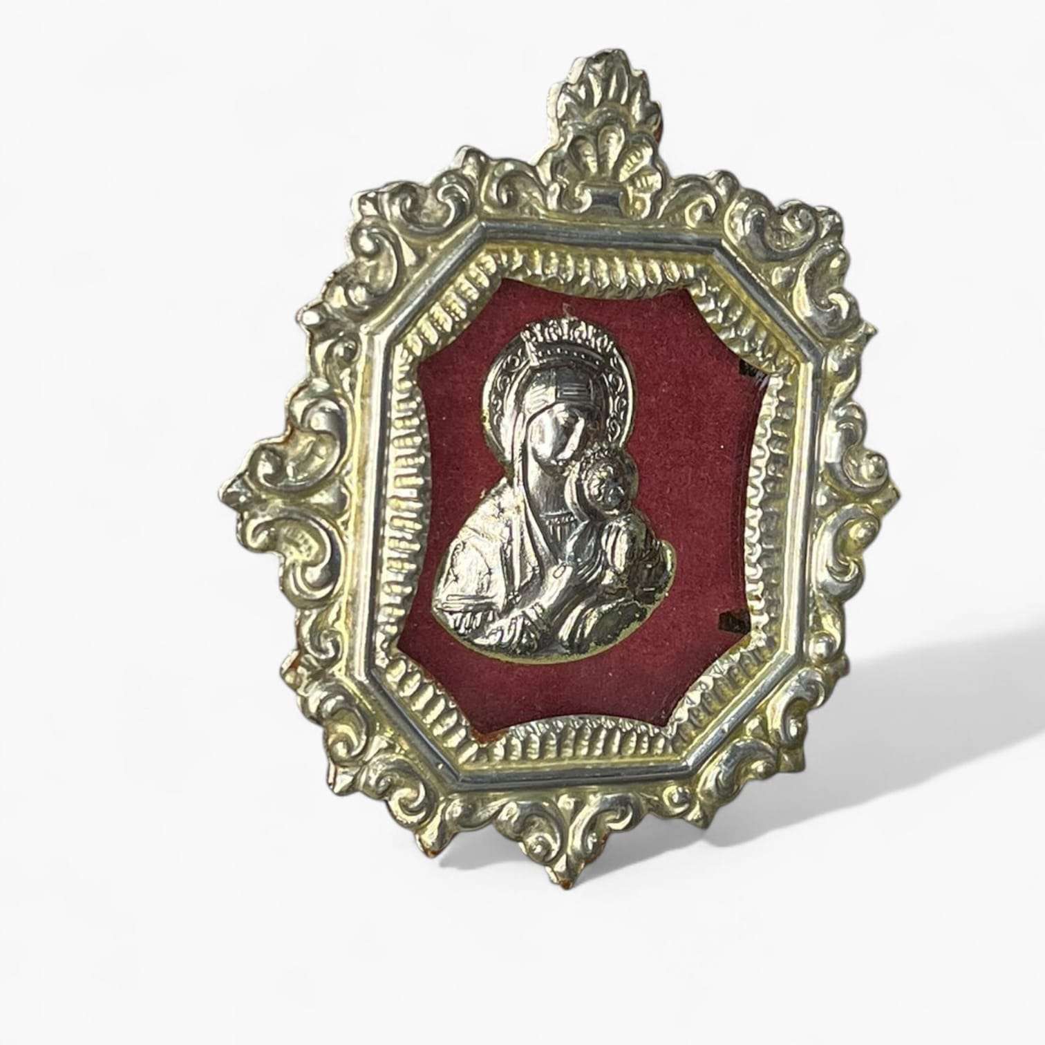 Vista frontal del relicario Virgen con Niño con marco ornamentado dorado.