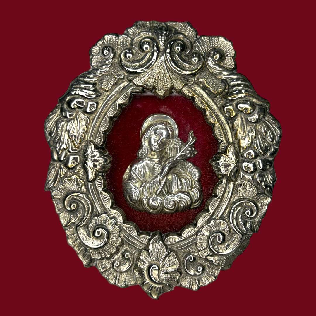 Este Relicario representa a Santa Filomena sosteniendo un lirio o una palma, símbolos universales de pureza, fe y martirio. 
