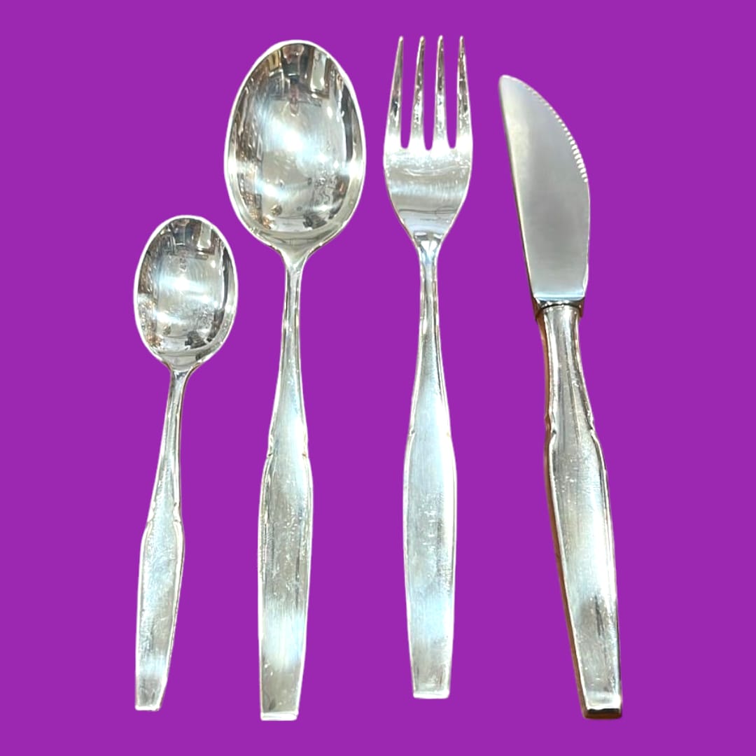 Conjunto de cubiertos de metal plateado con acabado brillante y diseño clásico, ideal para decoración de interiores con estilo vintage.