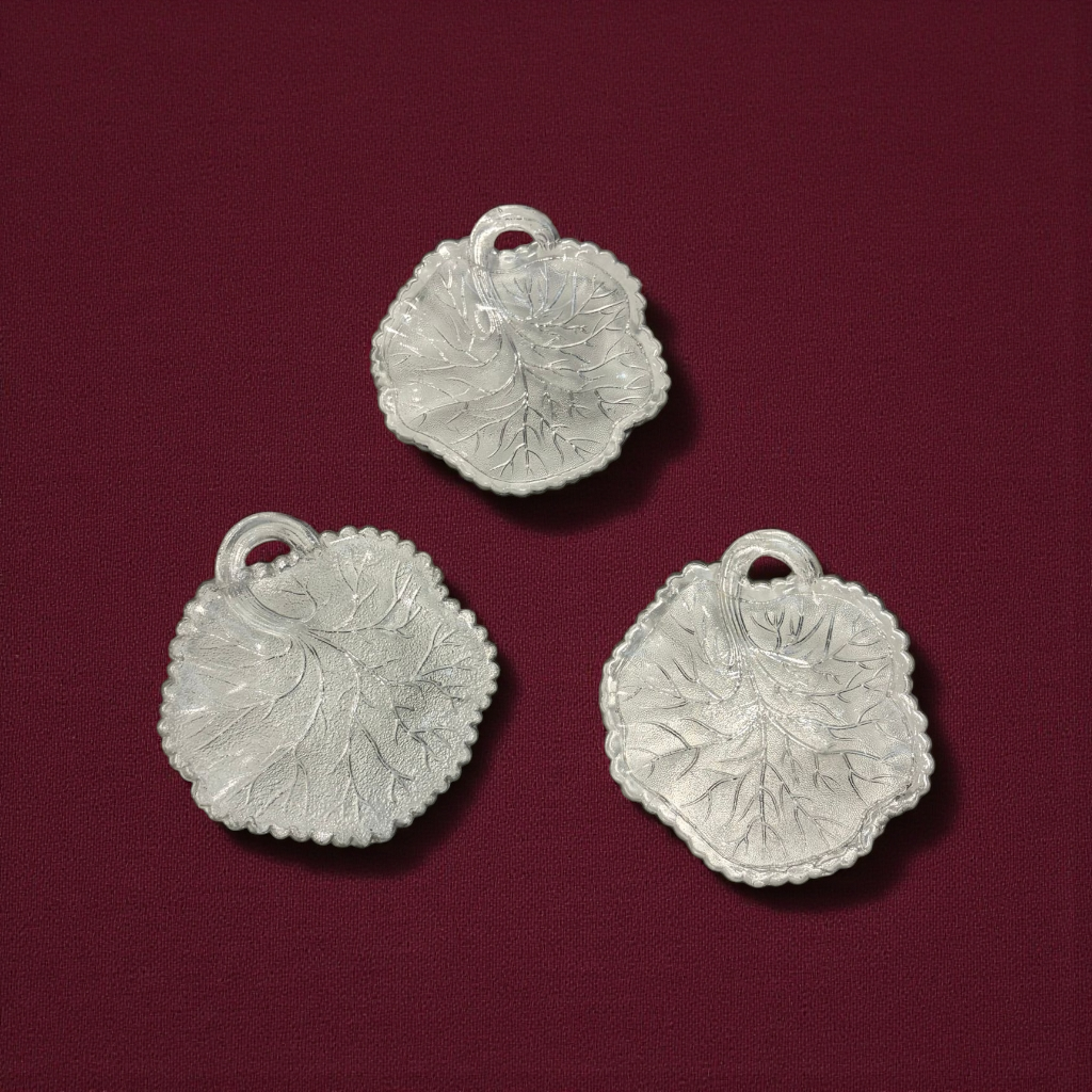 Lote de platos de cristal con forma de hoja antiguos sobre fondo burdeos. Diseño detallado ideal para decoración vintage en el hogar.
