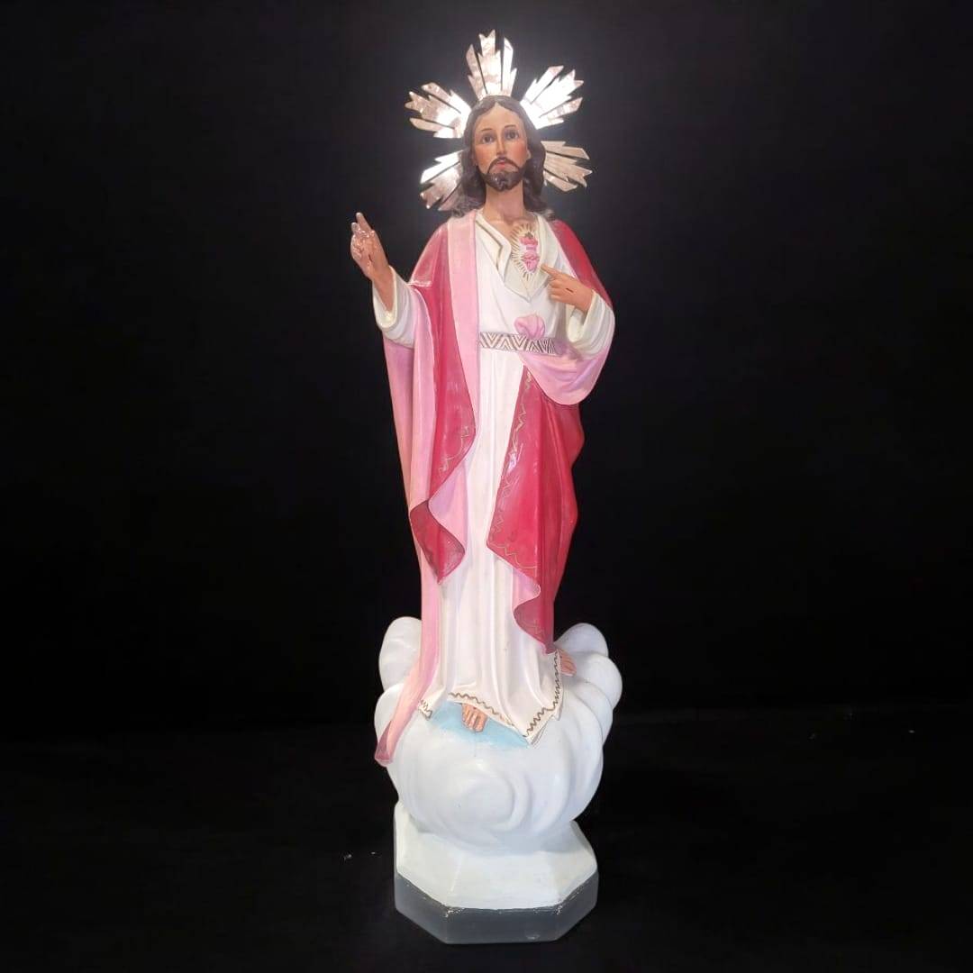 Figura Sagrado Corazón de Jesús majestuosa y religiosa sobre base de nubes, con túnica blanca y manto rojo, ideal para decoración sacra.