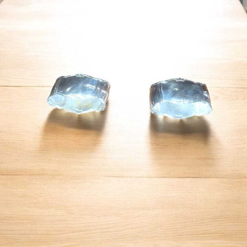 Servilleteros de metal plateado con diseño elegante sobre mesa de madera clara. Decoración clásica para mesas sofisticadas en el hogar.