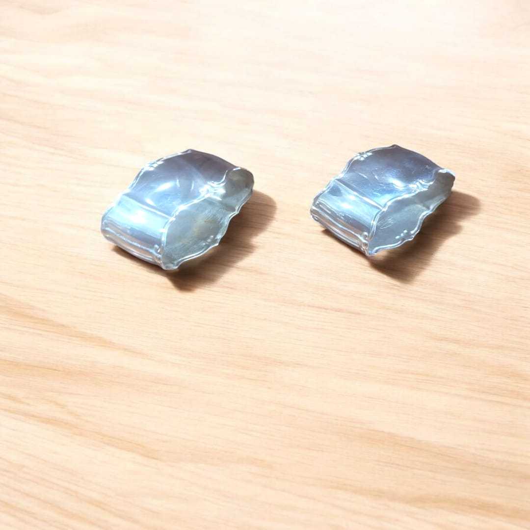 Servilleteros de metal plateado con diseño elegante sobre superficie de madera clara, ideales para decoración de mesa clásica en el hogar.